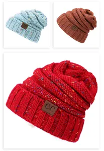 Close-up of knit beanie with colorful speckles and rectangular brown leather patch