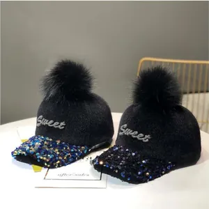 Detalle de gorras de béisbol negras de felpa con pompones y lentejuelas Sweet brillantes