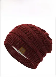 Close-up of deep red knit star beanie with warm white fleece lining and star leather tag