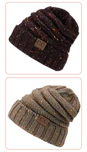 Detail of multi-color flecked knit beanie caps featuring dark brown embossed leather patches