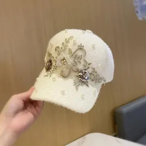 Weiße Plüsch-Basecap für den Winter mit goldener Blumenspitze und Perlenverzierung