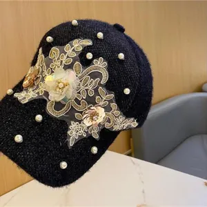 Details der schwarzen Tweed-Baseballkappe mit Perlen und floraler Spitzenstickerei