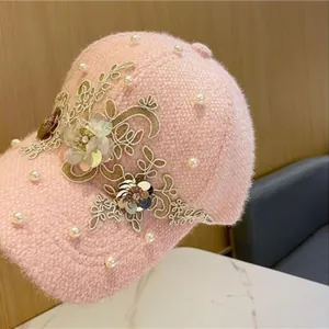 Detailaufnahme der rosa Plüsch-Baseballkappe mit Perlen und Blumenstickerei aus Spitze
