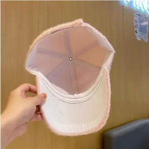 Detaillierte Innenansicht einer rosa Plüsch-Baseballkappe mit weißem Futter und sauberen Nähten