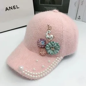 Vue détaillée de la casquette rose en peluche avec breloque cerf blanc et perles brodées