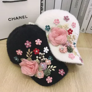 Close-up of elegant plush baseball caps featuring intricate handmade floral and pearl decor
