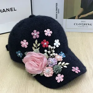 Close-up of black plush baseball cap with 3D floral accents and pearl details