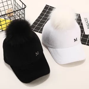 Warme Winter-Baseballkappe mit Kunstfell-Pompon und Metall-M-Logo in Schwarz und Weiß