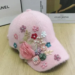 Detail of pink knitted baseball cap with 3D floral accents, pearls and crystal rhinestones