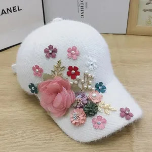 Close-up of plush white baseball cap with 3D floral, pearl, and rhinestone embellishments