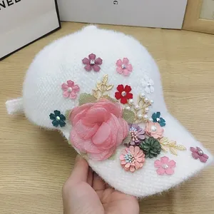 Detail of white plush baseball cap featuring 3D floral accents, pearls and rhinestones