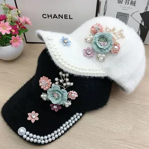 Furry winter baseball cap with plush fabric, pearls, and floral accents in black and white