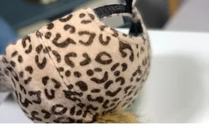 Détails de l'imprimé léopard et du pompon en fausse fourrure sur cette casquette de baseball