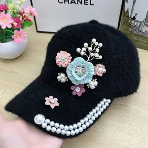 Detail of plush black baseball cap with 3D fabric flowers and pearl brim decorations