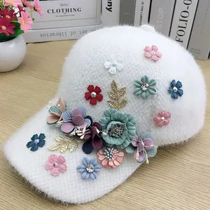 Detailed view of plush white baseball cap with colorful floral patches and rhinestones