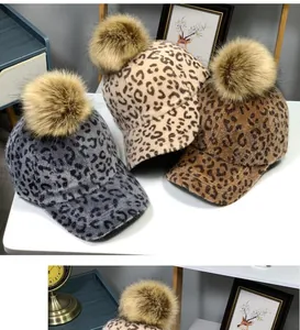 Trois casquettes léopard avec pompons en fourrure synthétique en gris, beige et marron