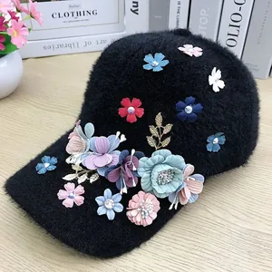 Close-up of 3D colorful fabric flowers and rhinestones on black plush baseball cap