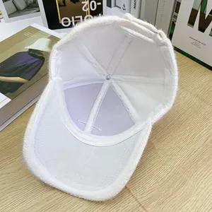 Detailed inner view of white plush baseball cap showing soft lining and stitch texture
