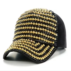 Close-up of black baseball cap featuring golden beads and diamond-like stud embellishments