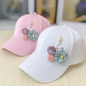 Women's pink and white baseball caps with 3D floral deer patches on wooden background