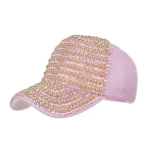 Detailed side view of pink baseball cap with sparkling rhinestones and golden pearls