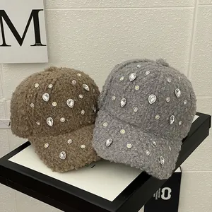Close-up of brown and grey plush baseball caps with sparkling rhinestone flower embellishments