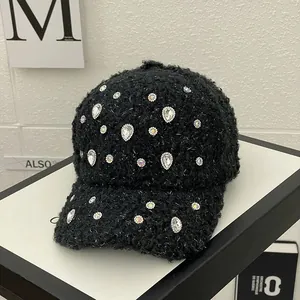 Detailed view of black rhinestone baseball cap with fleece texture and shimmering silver threads