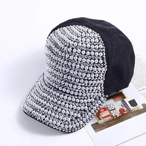 Detail of black baseball cap featuring shimmering silver rhinestones and grey pearls