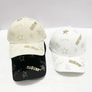 Détail de la broderie étoile dorée sur des casquettes en coton de trois couleurs