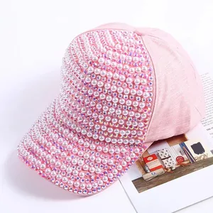Detailed view of pink baseball cap featuring rows of white pearls and sparkling rhinestones