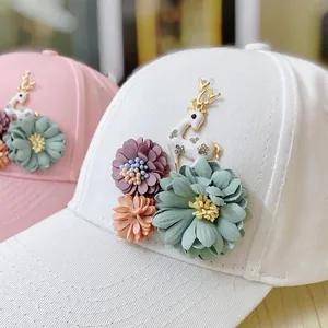 Detail of 3D floral accents and golden deer emblem on a stylish cotton baseball cap