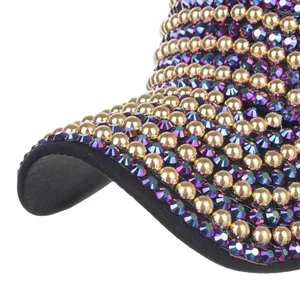 Detailed close-up of purple rhinestones and gold studs on a black baseball cap