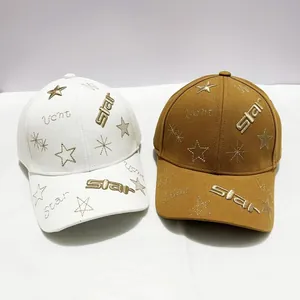 Vue détaillée des broderies d'étoiles sur casquettes de baseball en coton blanc et marron