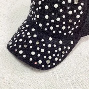 Close-up of elegant black faux mink baseball cap with luxury white pearls and rhinestones