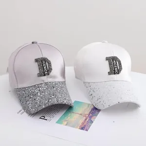 Fashionable satin baseball caps with rhinestone D logo and sequined brims in silver and white