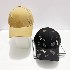 Dettagli di cappellini da baseball in cotone nero e kaki con motivi a cuore Love ricamati
