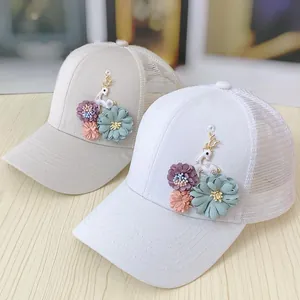 Detail of floral appliques and golden deer ornament on breathable mesh baseball cap