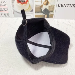 Detail of black faux fur baseball cap showing interior lining and silver metal buckle