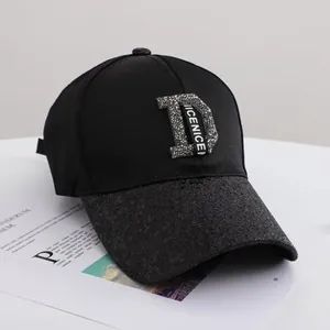 Detail of black baseball cap with rhinestone D logo and glittery texture on the brim