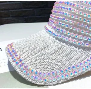 Detailed macro view of white knitted sun hat with shimmering AB rhinestones and sequins