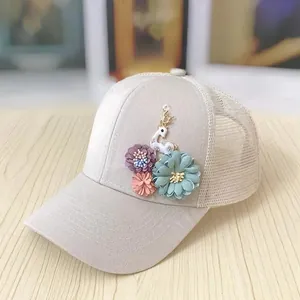 Detail of handmade floral appliques and a cute 3D deer on a beige mesh sun hat