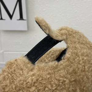 Detail of brown fleece baseball cap showing the adjustable black velcro strap closure