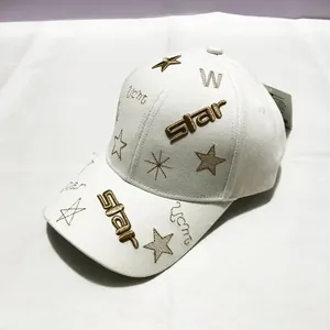 Détail de la broderie étoile dorée et texture de toile sur casquette de baseball beige