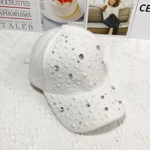 Detail of white faux fur baseball cap with sparkling rhinestones and elegant pearls decoration