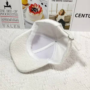 Close-up of white plush baseball cap interior showing sewing lines and metal buckle
