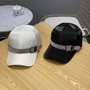 Luxe satin baseball caps in black and white with sparkling rhinestone bands and metal buckles