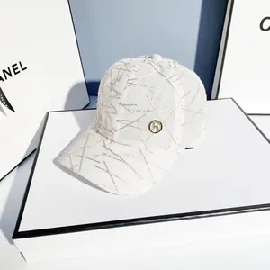 Stylish white baseball cap with silver embroidery and metal logo ring on display box