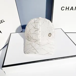 White baseball cap with silver glitter abstract lines and a metal badge on white stand