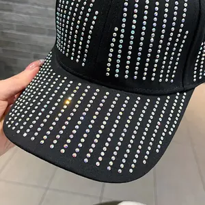 Detailed view of shimmering AB rhinestones on black cotton fabric of a baseball cap