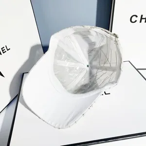 Detail view of white baseball cap with breathable mesh lining and adjustable silver buckle